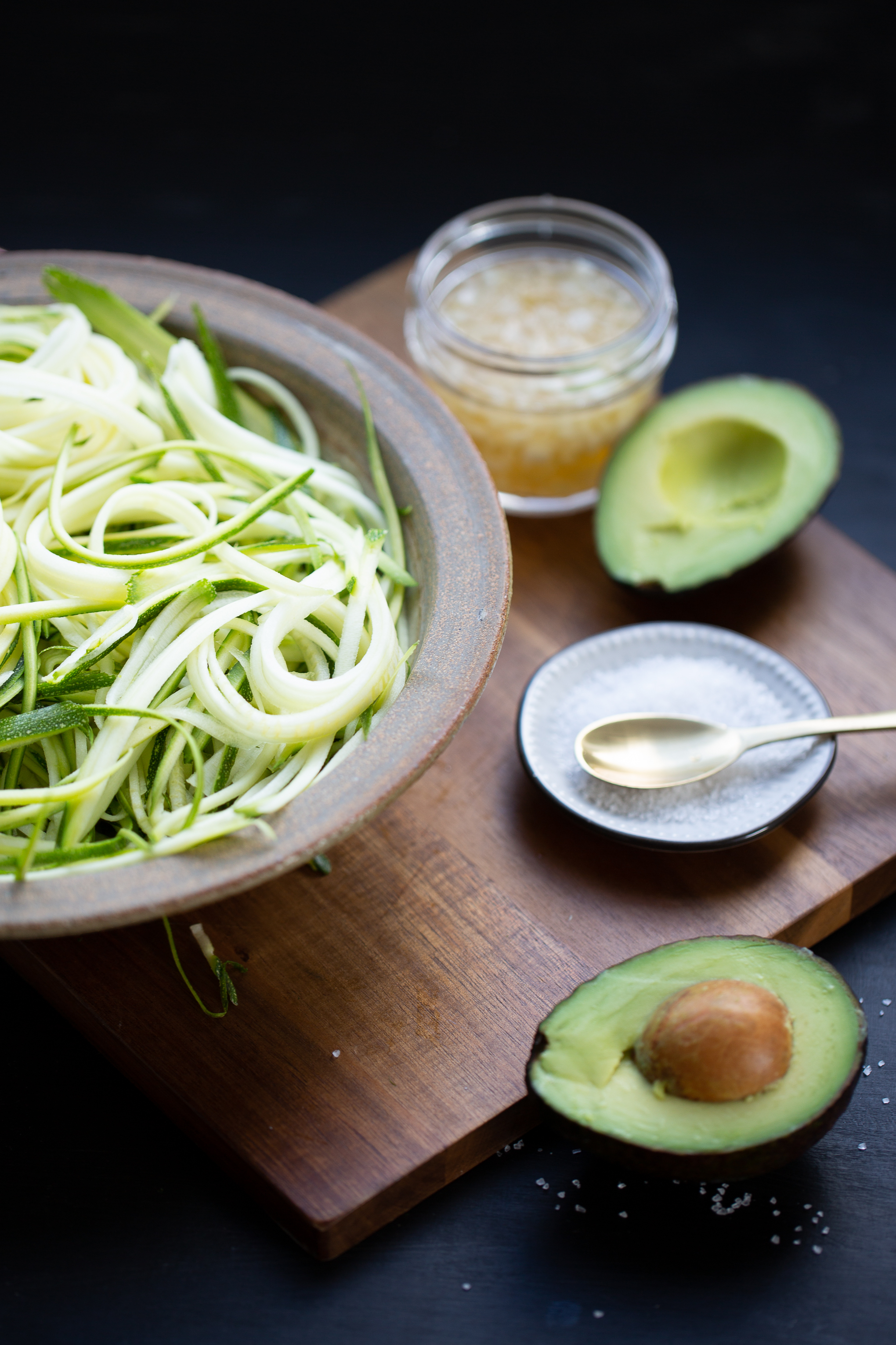 noodles de zucchini en tazón y un aguacate partido a la mitad