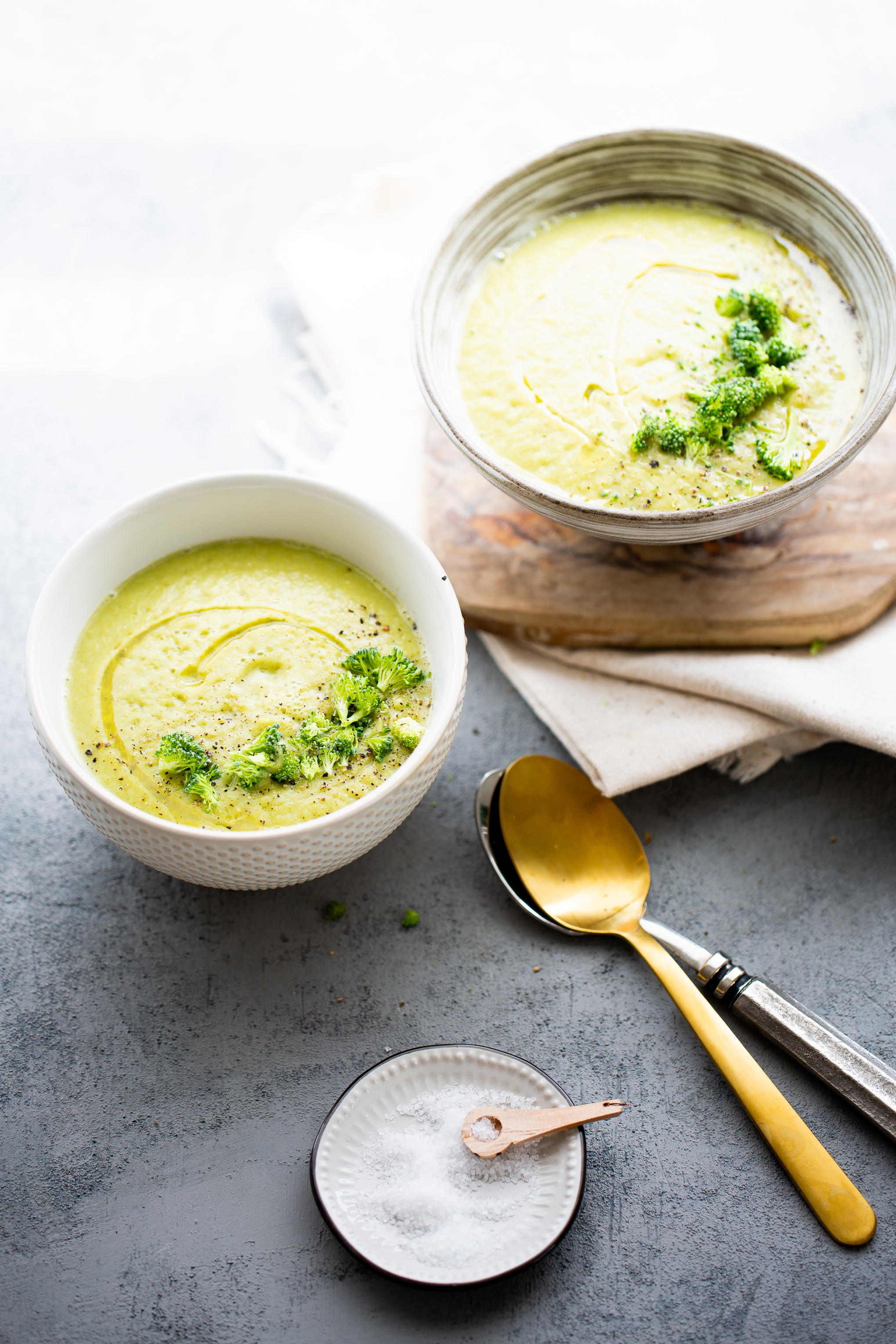 dos tazones con crema de brocoli vegana decorados con brocoli crudo