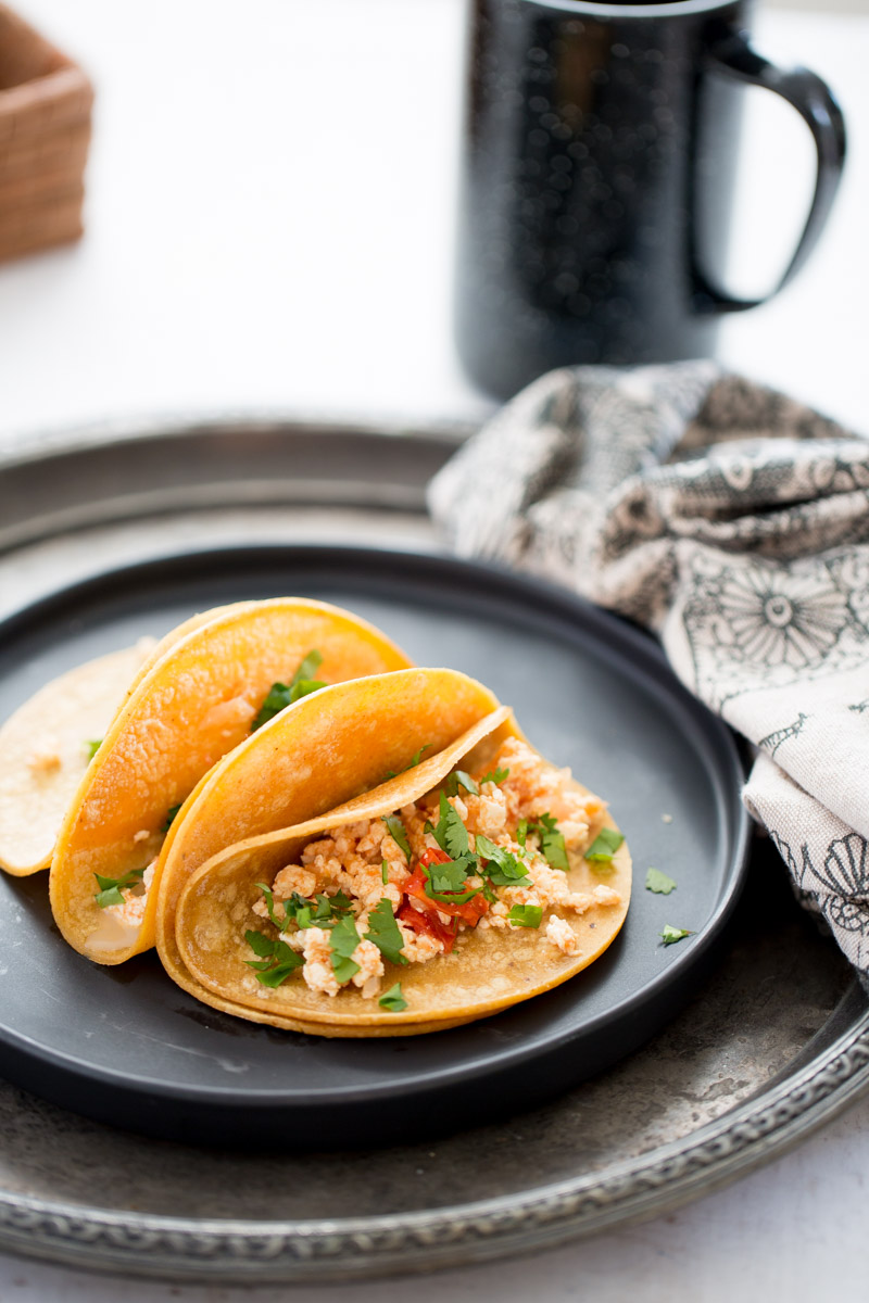 Plato con dos tacos de tortillas de maÃ­z rellenos de tofu a la mexicana.