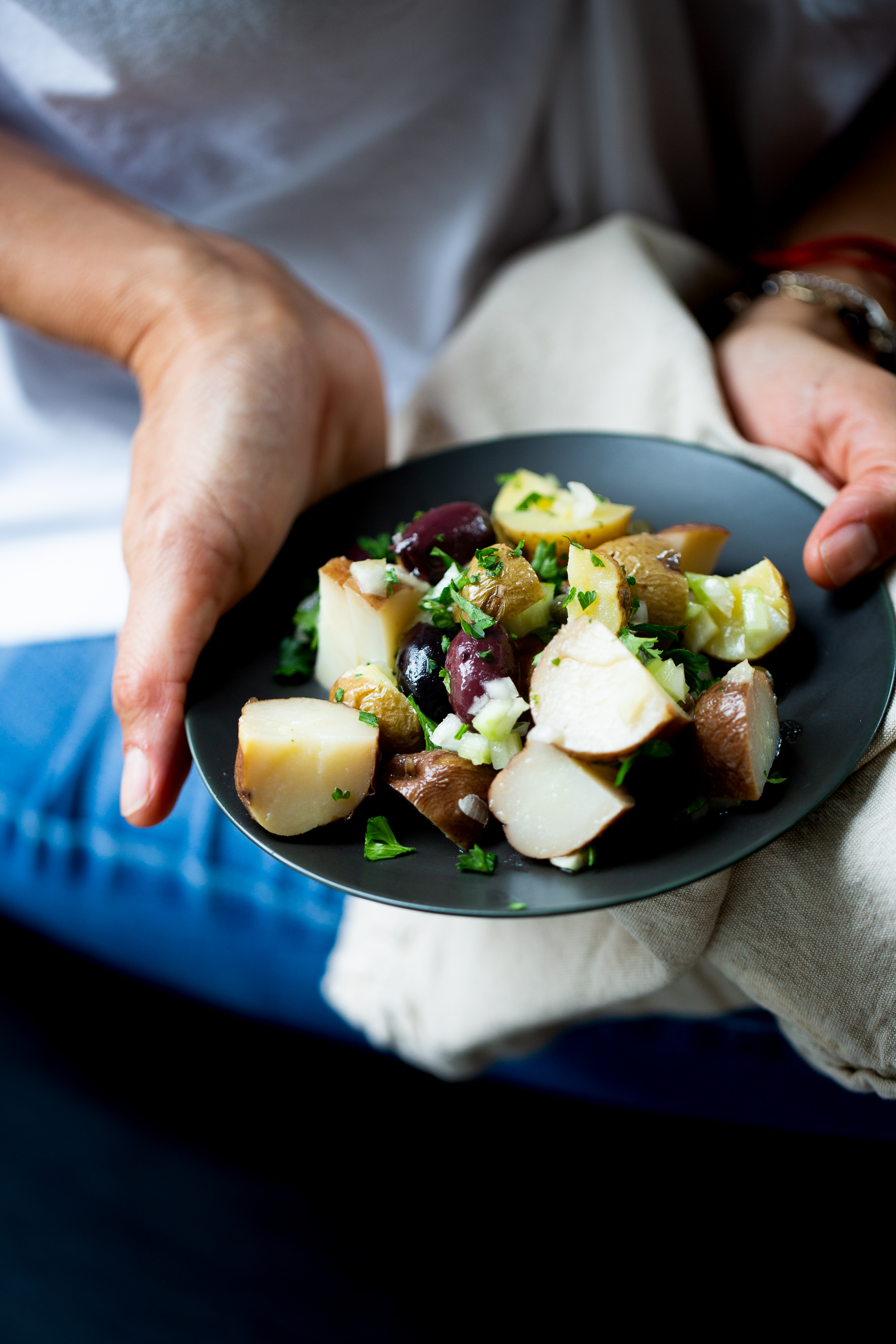 Ensalada de papa vegana servida en un plato obscuro