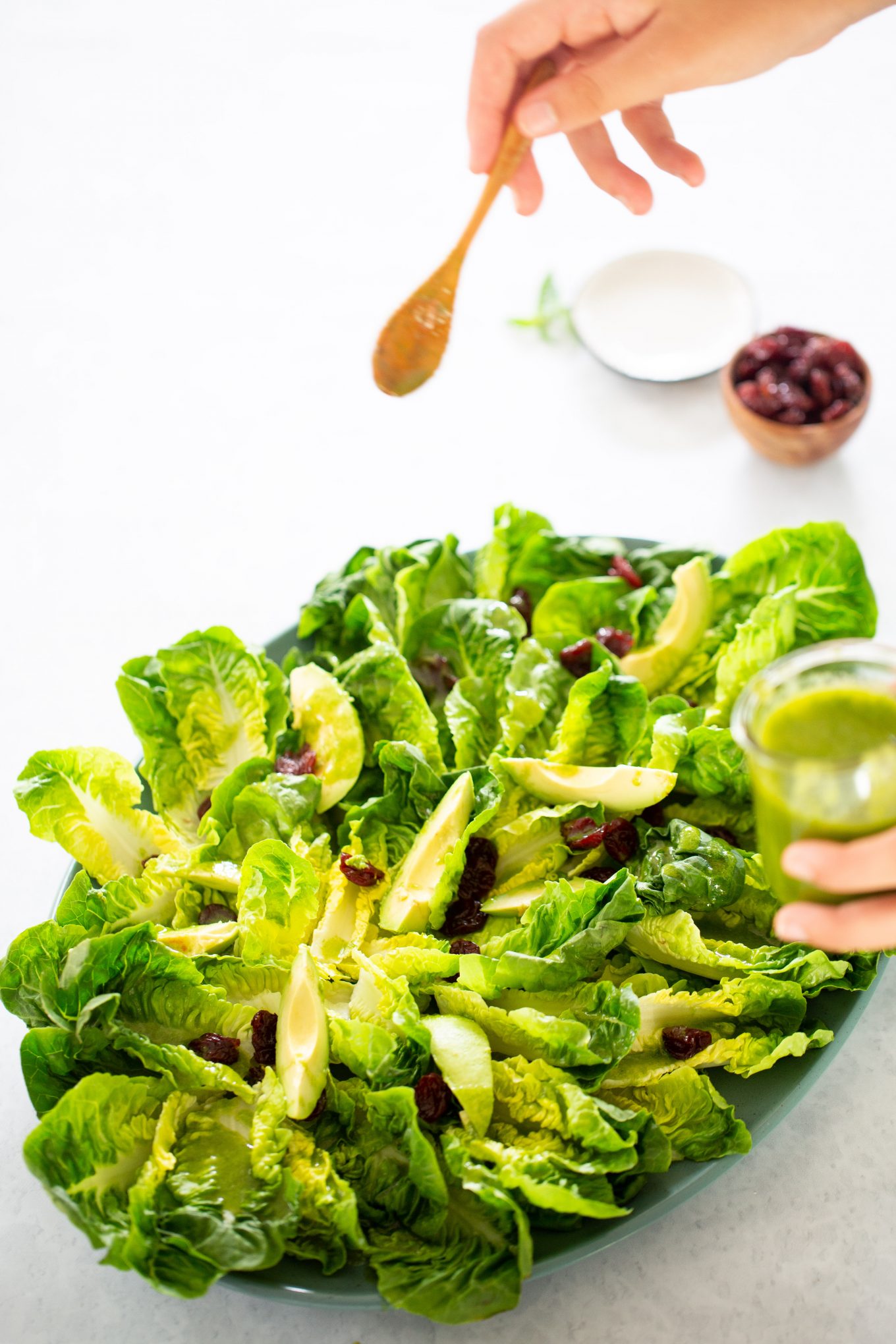 gotas de Aderezo de albahaca cayendo sobre ensalada de hojas verdes