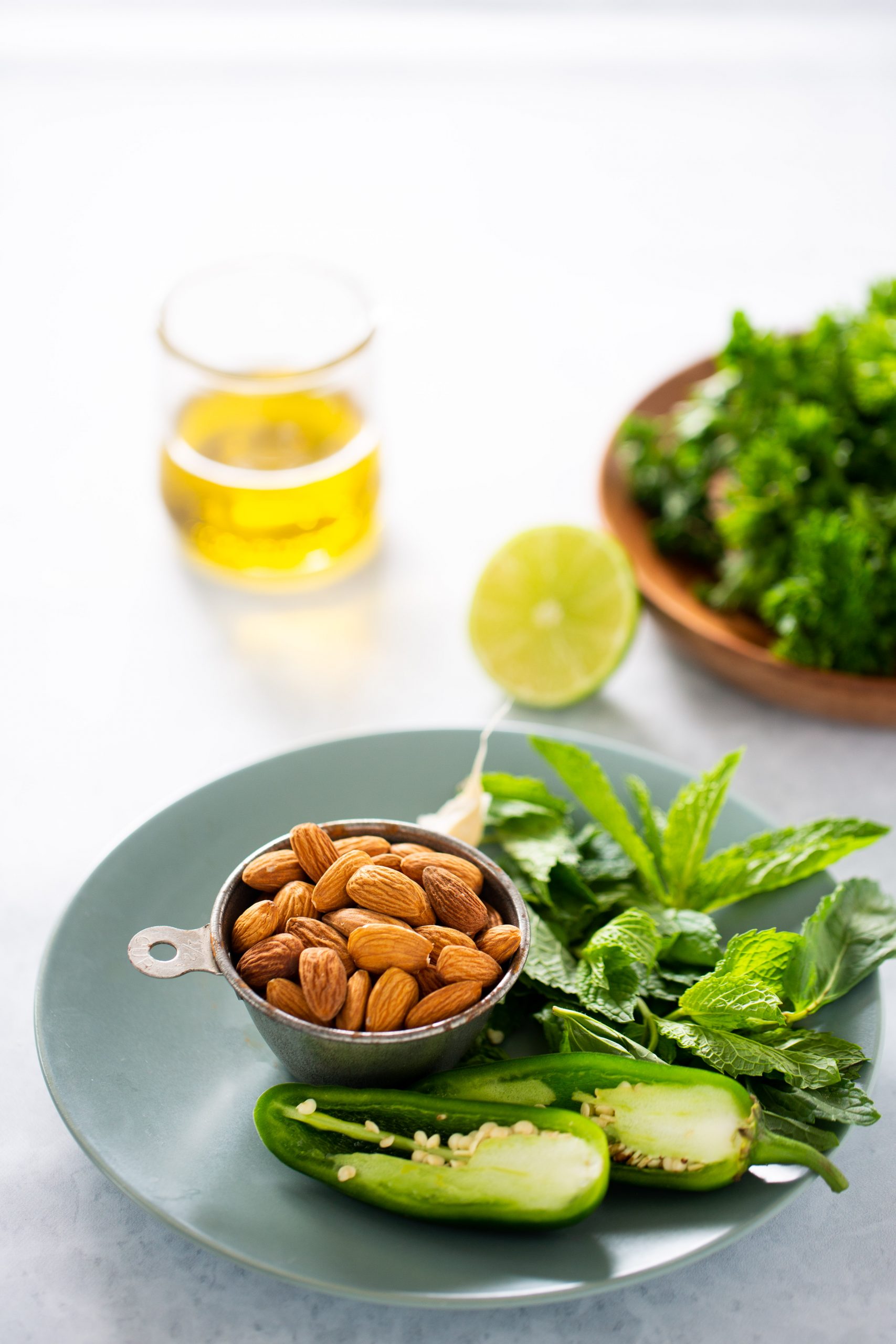 Almendras, jalape&ntilde;o y hojas de menta sobre un plato verde