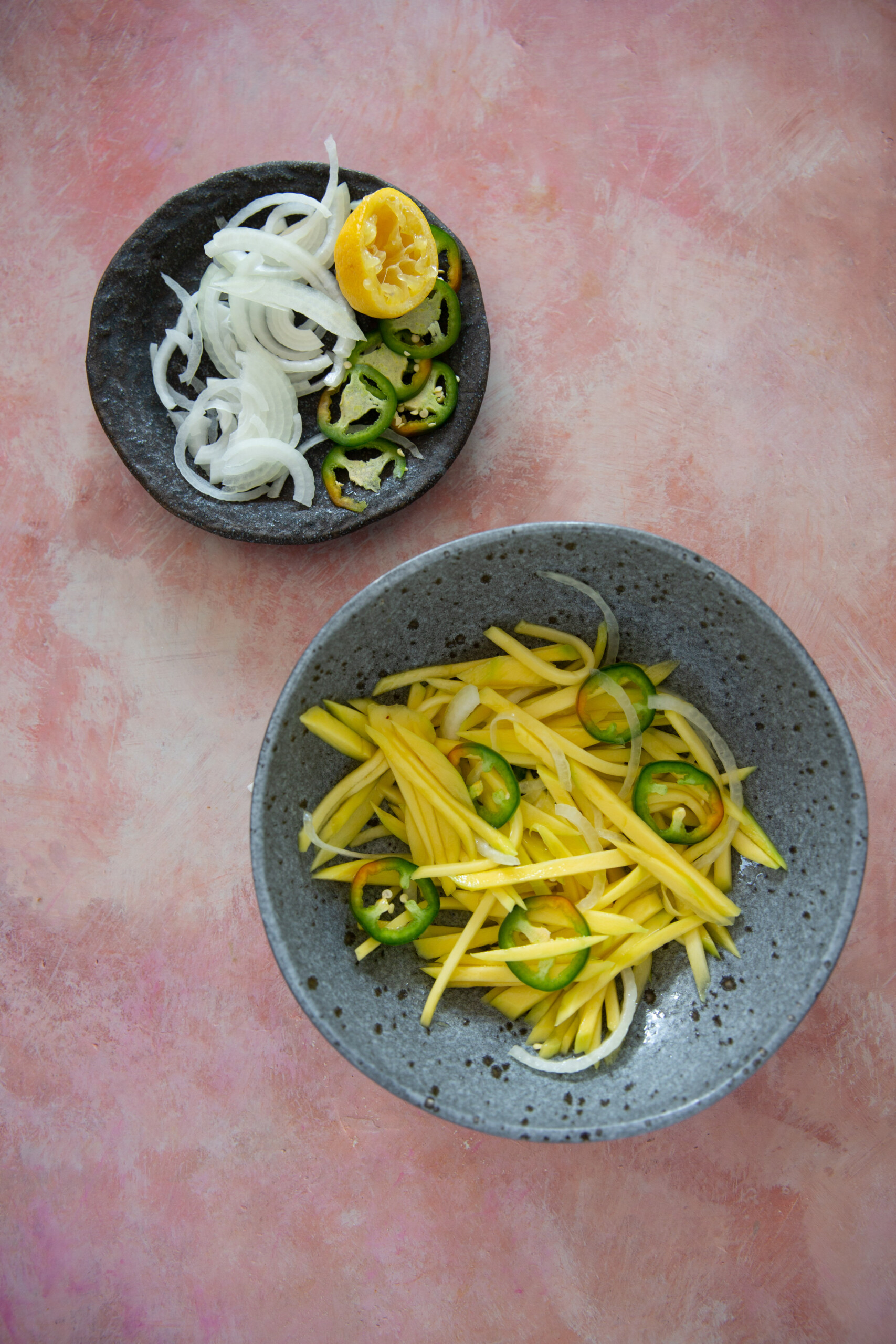 Rebanadas de mango verde con chile en polvo y sal sobre un plato.