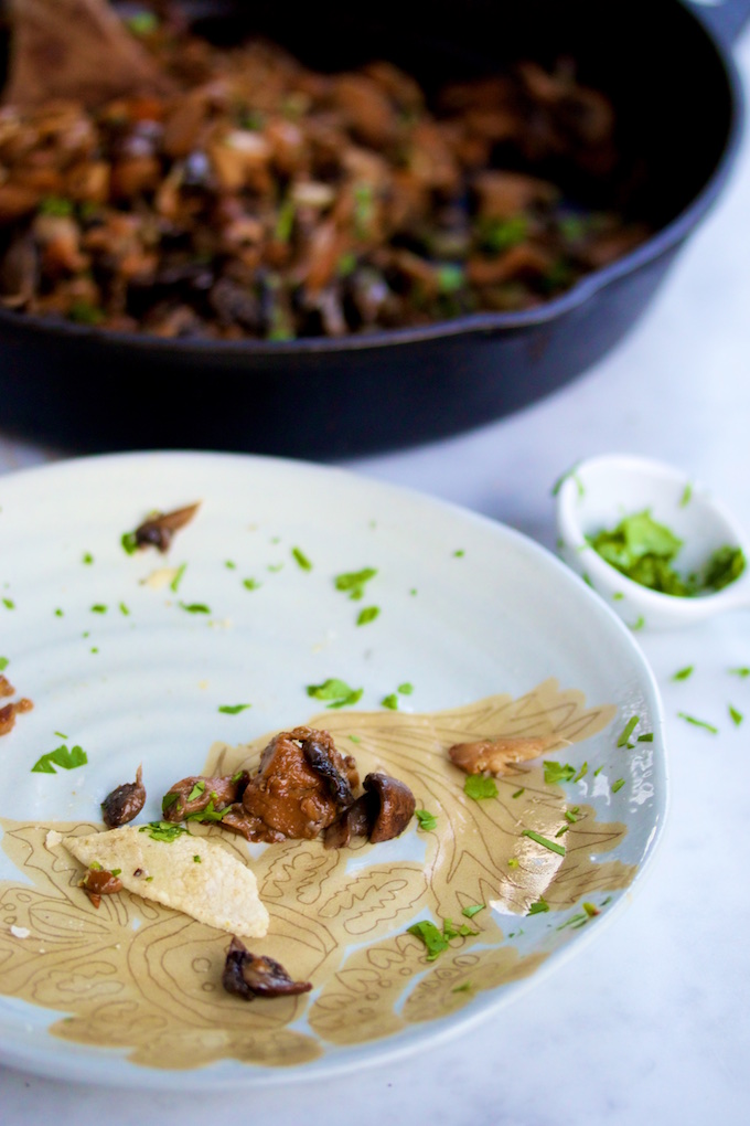 Un plato con la última mordida de un tacos champiñónes
