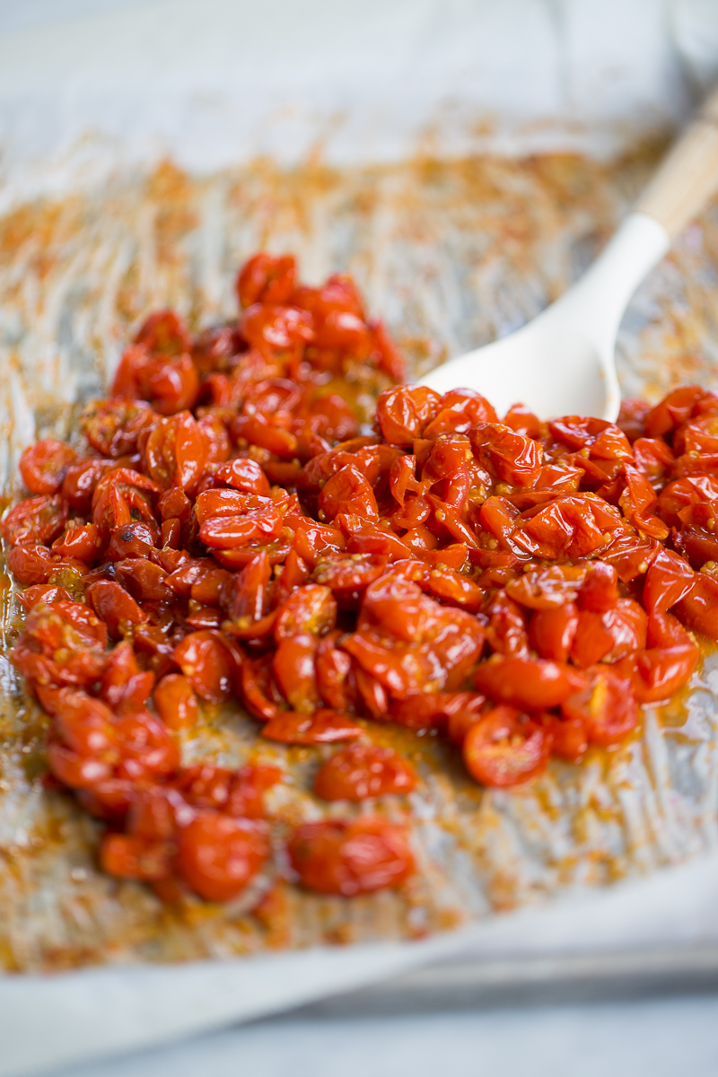 Tomates rostizados en una charola con papel de horno.