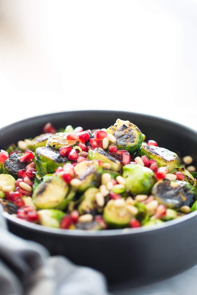 Ensalada de coles de bruselas con aderezo picante, granada y piñones.