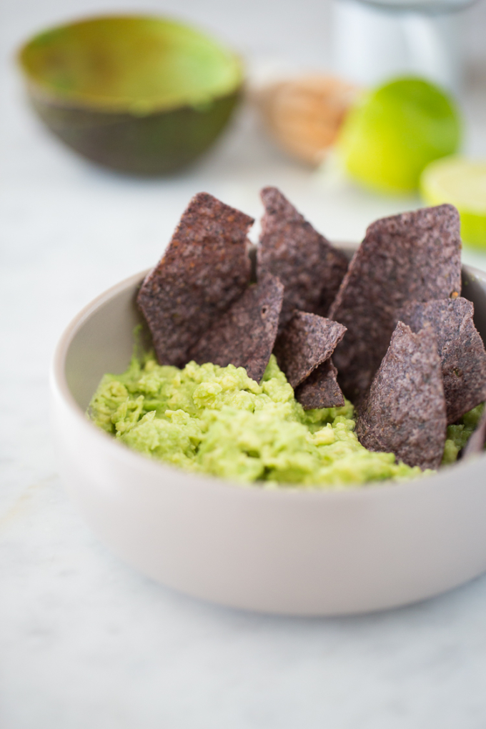 Tazón con guacamole y totopos de maiz morado