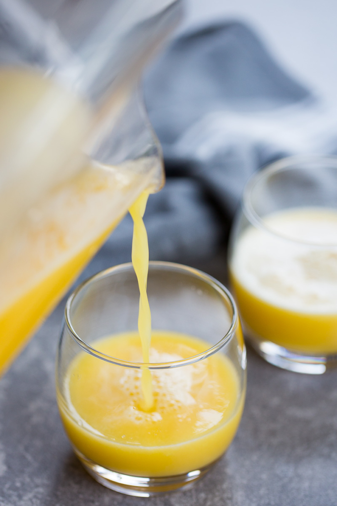 Sirviendo jugo de piña con manzana en un vaso