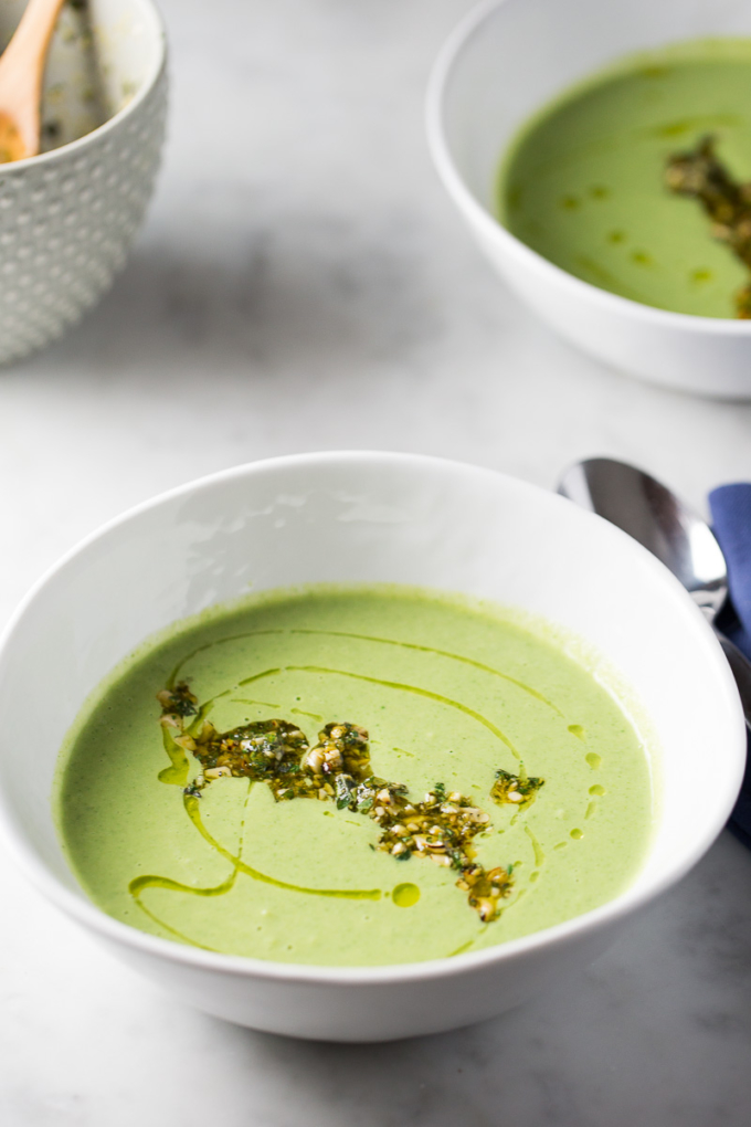 sopa de brocoli en un tazón blanco con aceite de oliva y salsa de cashews
