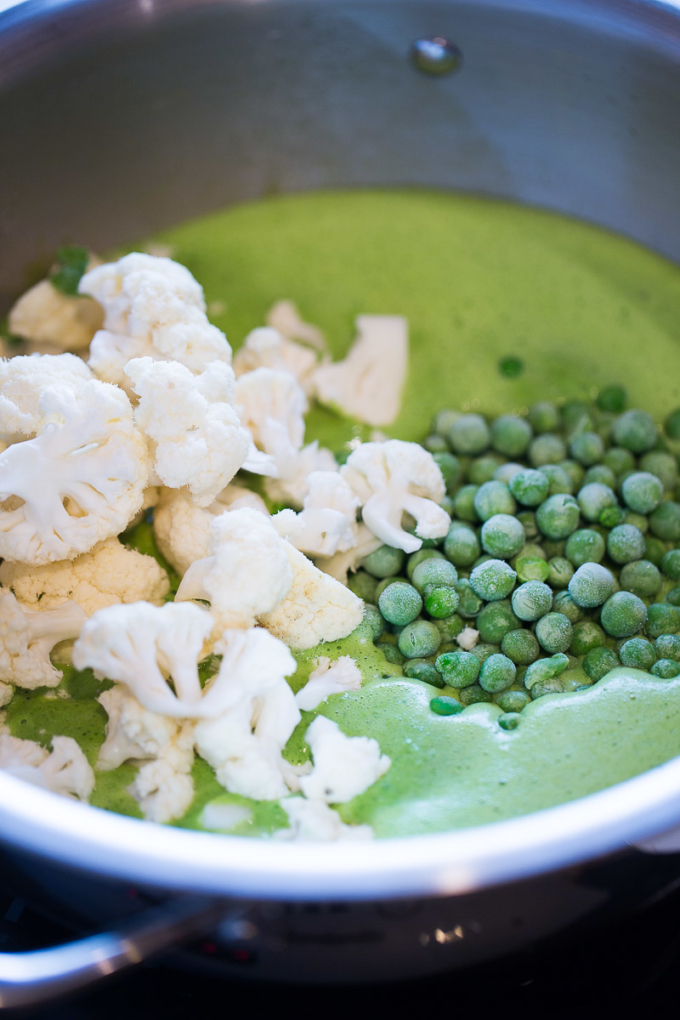 coliflor y chícharos en una olla con curry verde