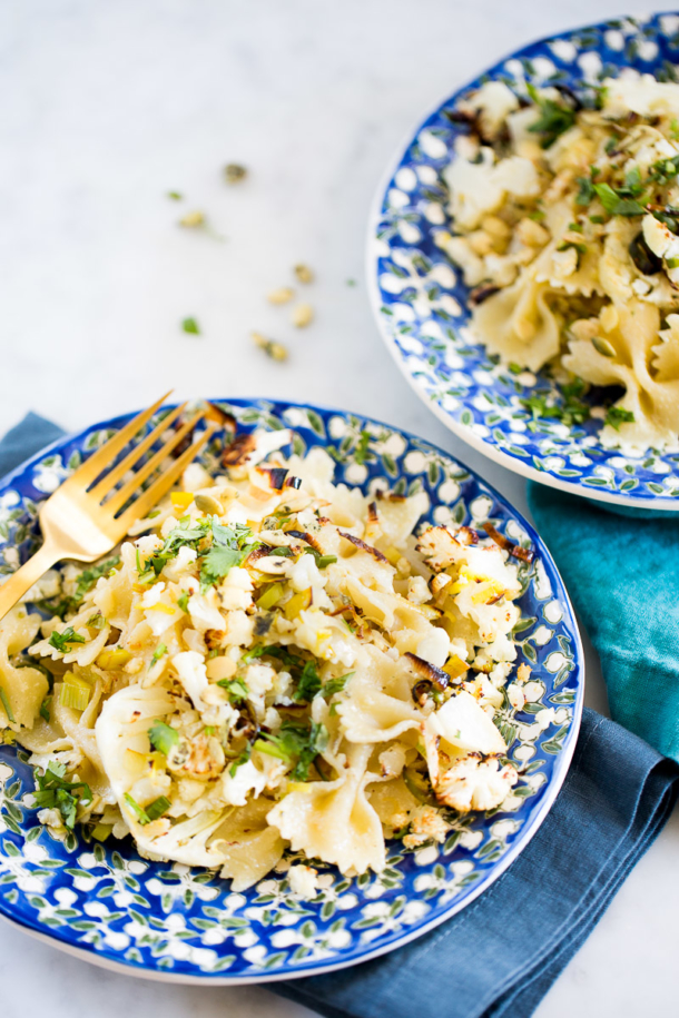 Pasta con coliflor y poro rostizada con aderezo de semillas de calabaza y limón. Receta vegana.