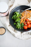 The Mexican Buddha bowl is a bowl with rice, sautéed green leaves, roasted vegetables and chickpeas in a creamy sauce of Oaxacan mole Coloradito.