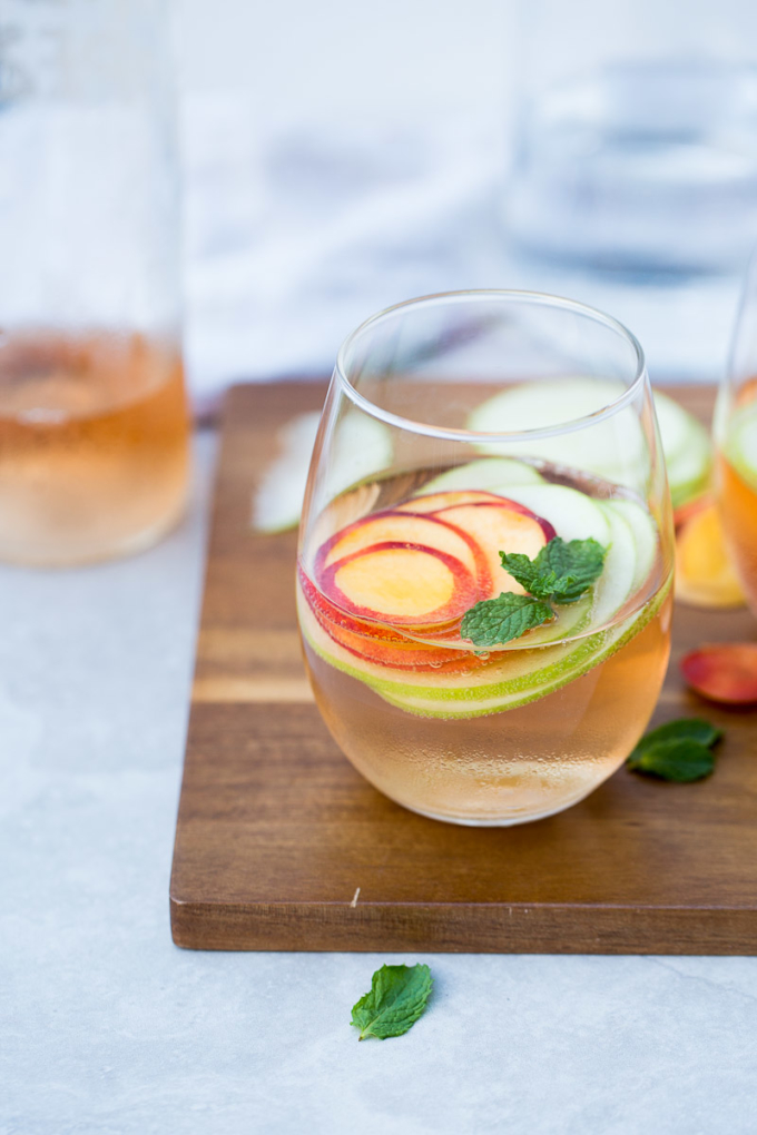 Receta para hacer sangría de verano con vino rosado y fruta de la estación.