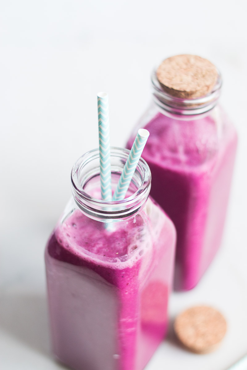 dos botella de smoothie rosa com popote blanco con azul.