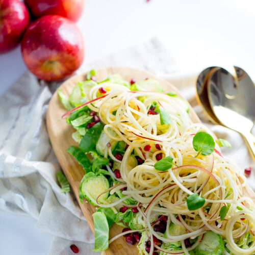 Apple salad with brussels sprouts, pomegranate seeds, and maple- balsamic vinegar dressing