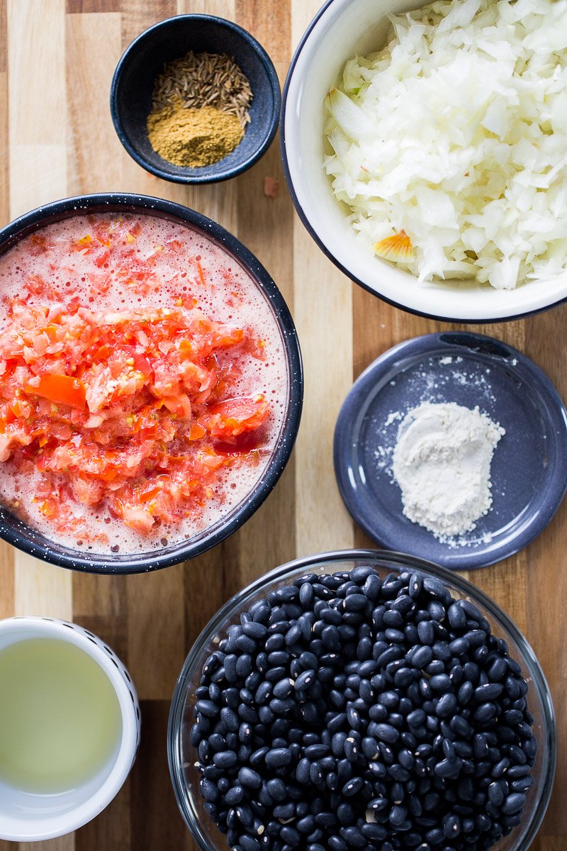 tomate picado, cebolla picada, frijol negro y especias para hacer sopa de frijol