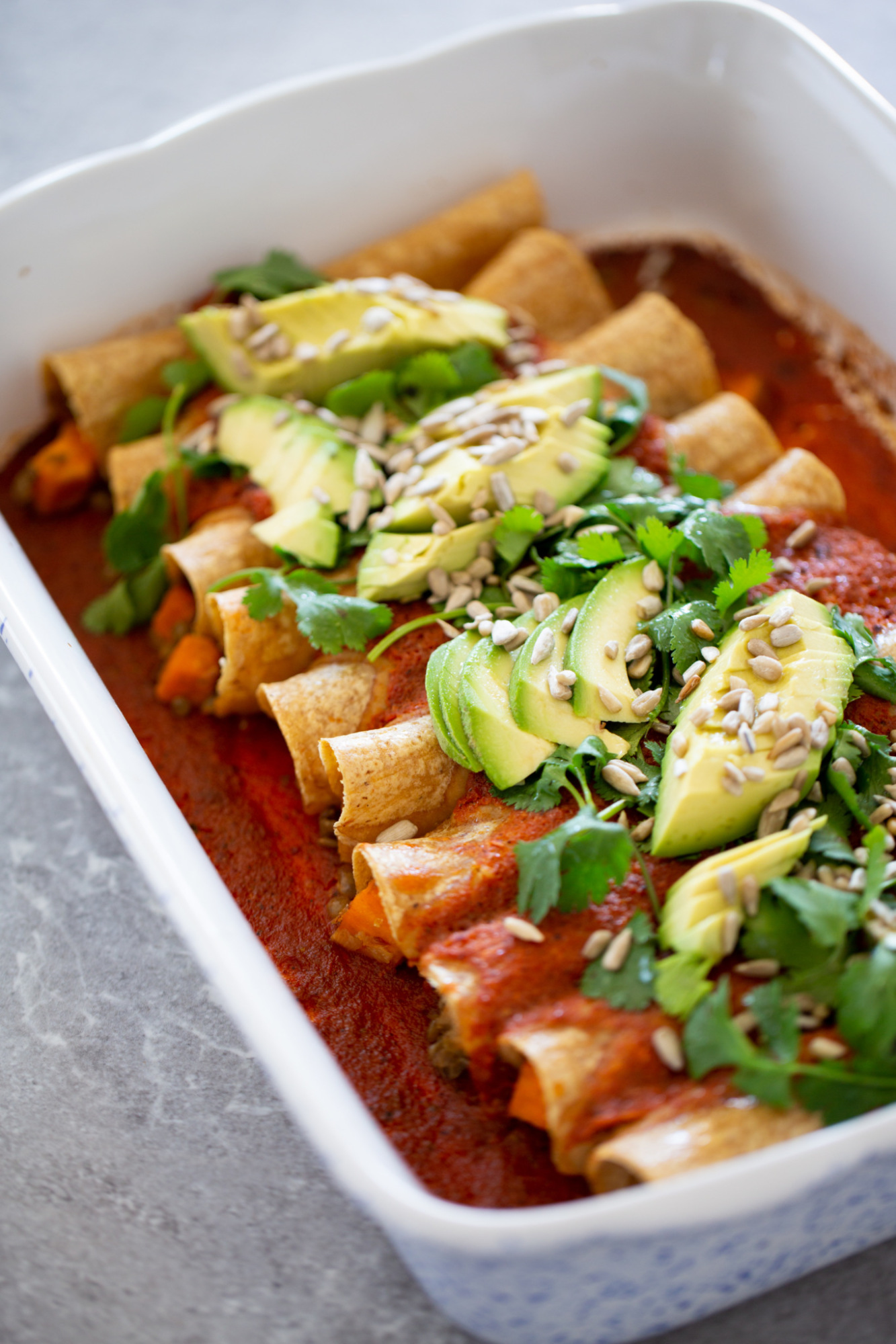 Enchiladas veganas de camote y lenteja con salsa roja.