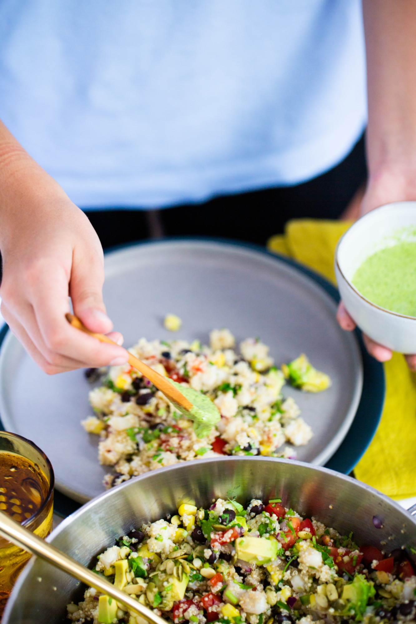 poniendo crema de cilantro sobe ensalada mexicana de quinoa