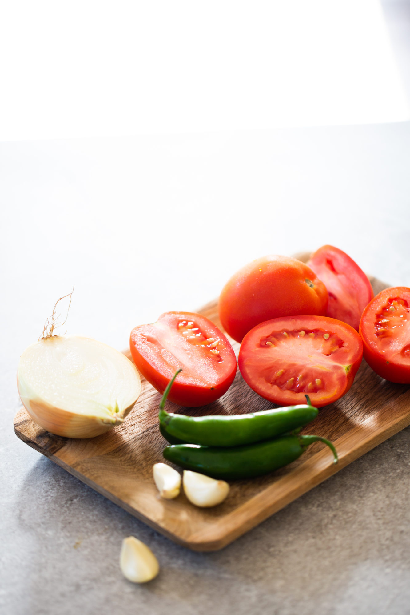 Tomate, cebolla chile serrano y ajo para hacer salsa mexicana.