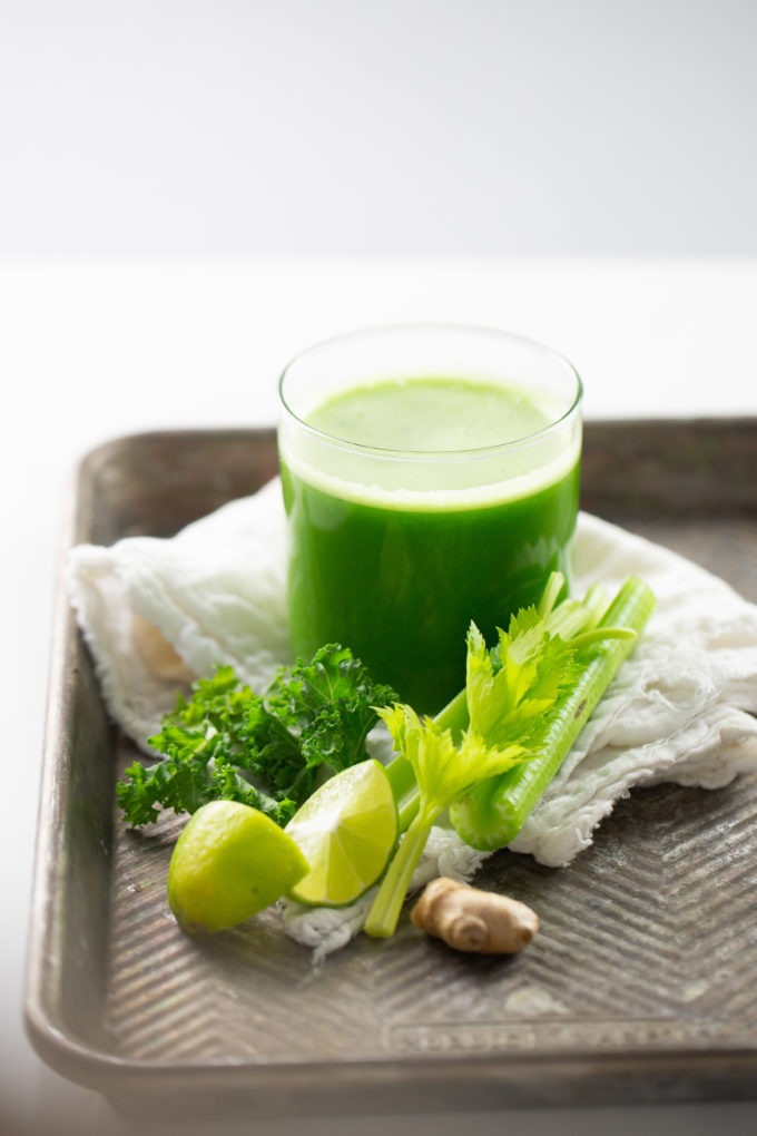 jugo verde con limón y apio a un lado