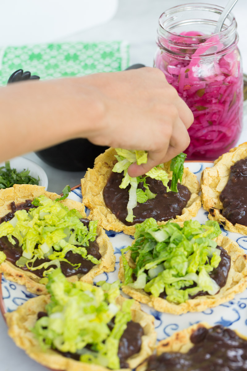 Terminando los sopes veganos con lechuga