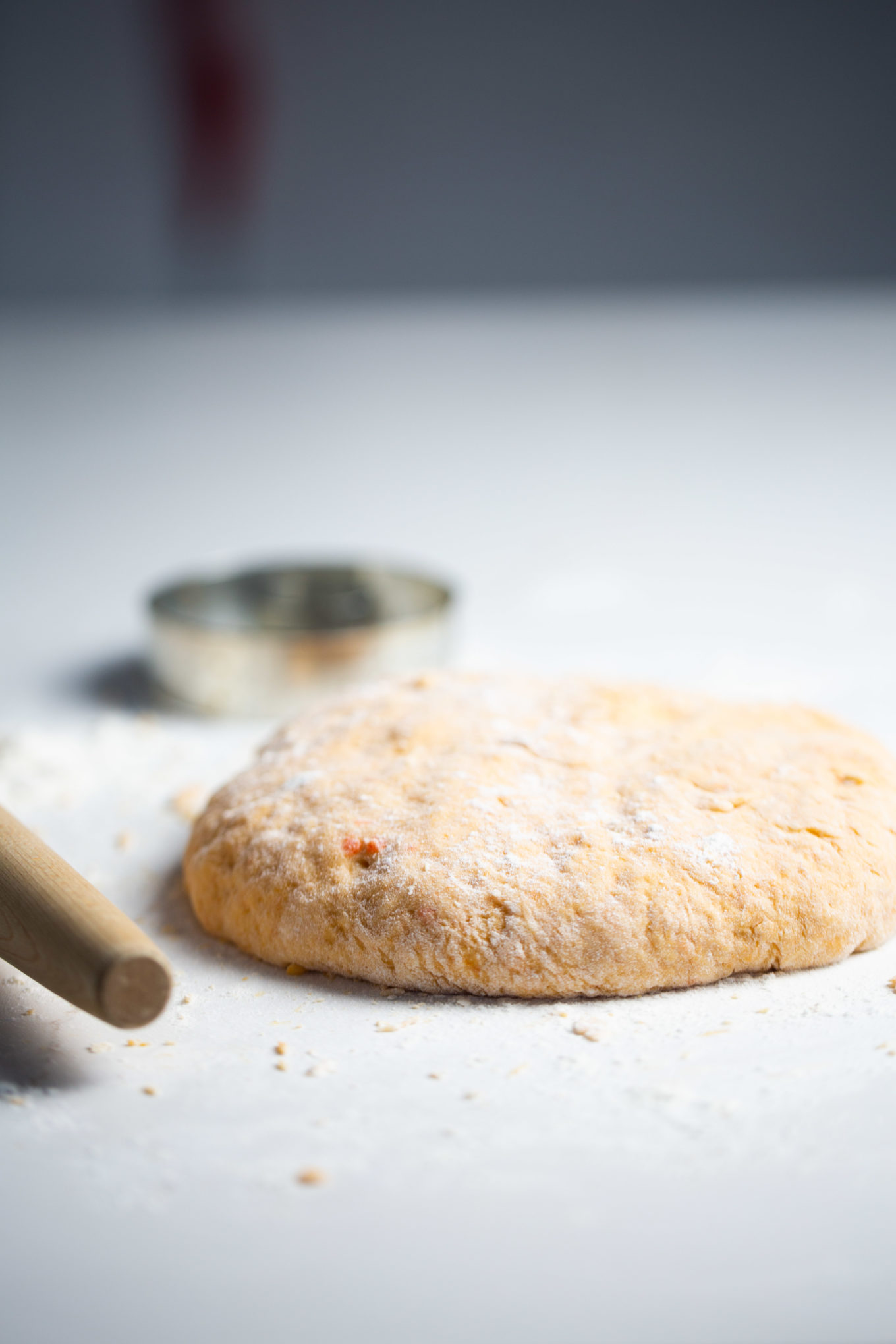 dough next to a rolling pin and cutter