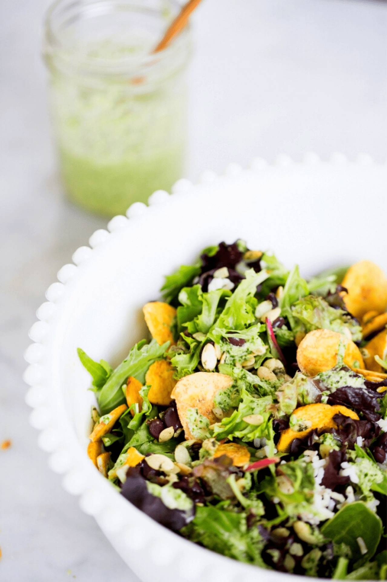 Ensalada de hojas verdes con platanitos y frijoles y aderezo de ciantro vegano