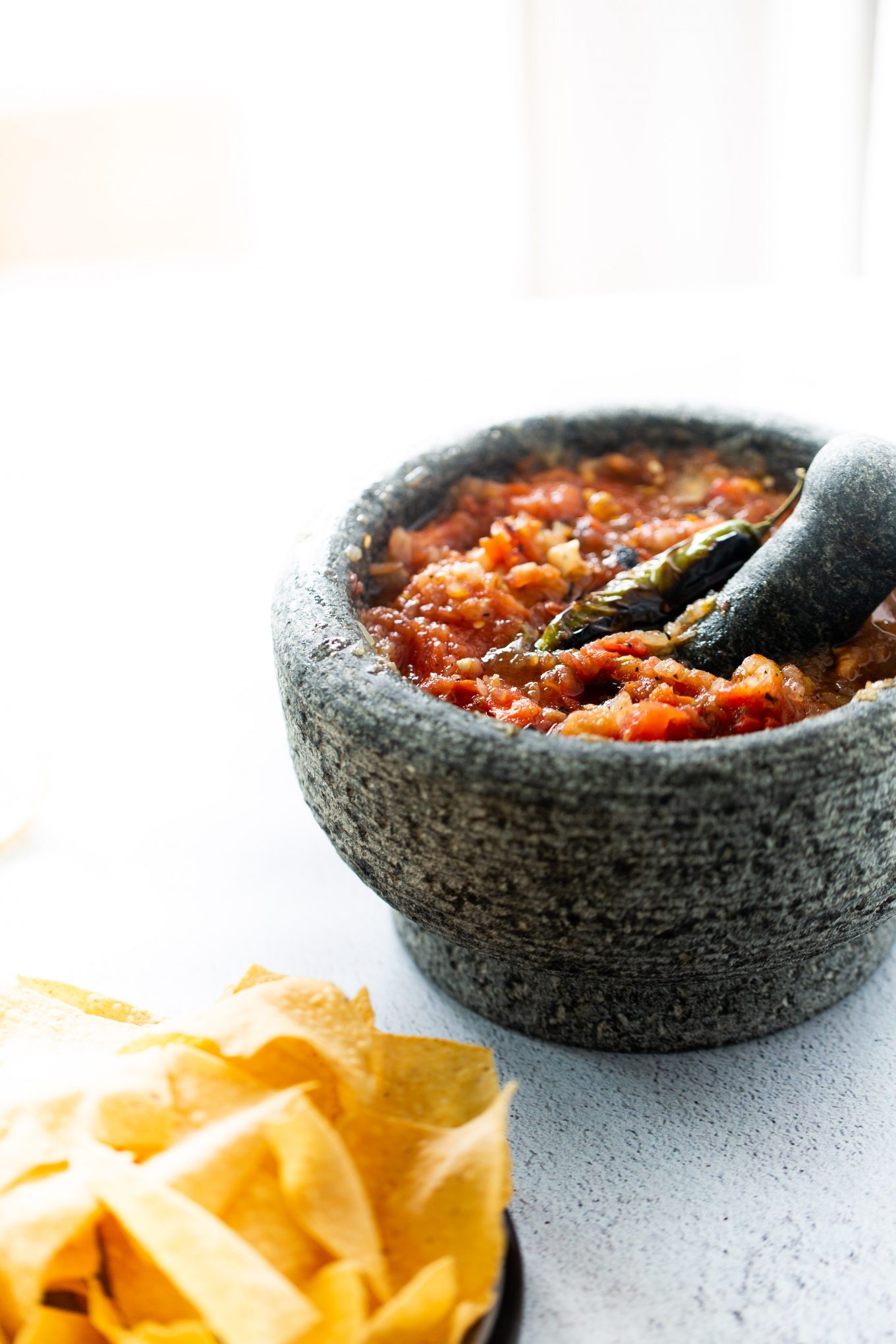 Salsa en un molcajete con chips a un lado.