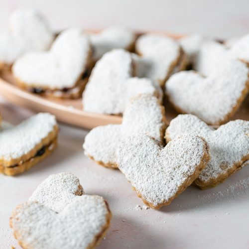 Galletas de corazón veganas en un plato con azúcar en polvo.