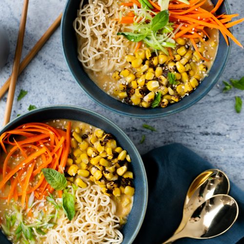 Dos tazones de sopa de fideos ramen con zanahorias y fideos.