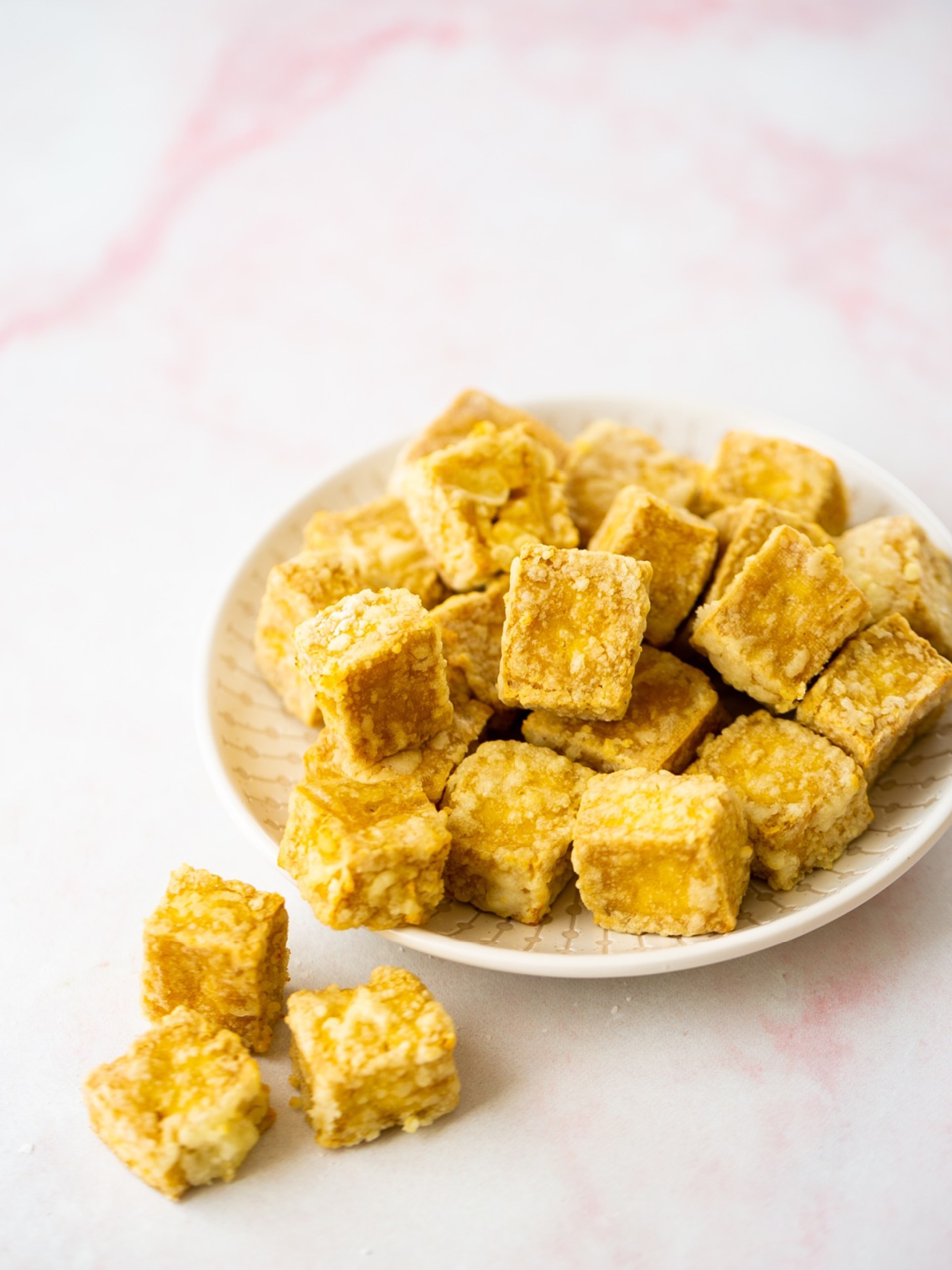 Cubos de tofu en un plato blanco.