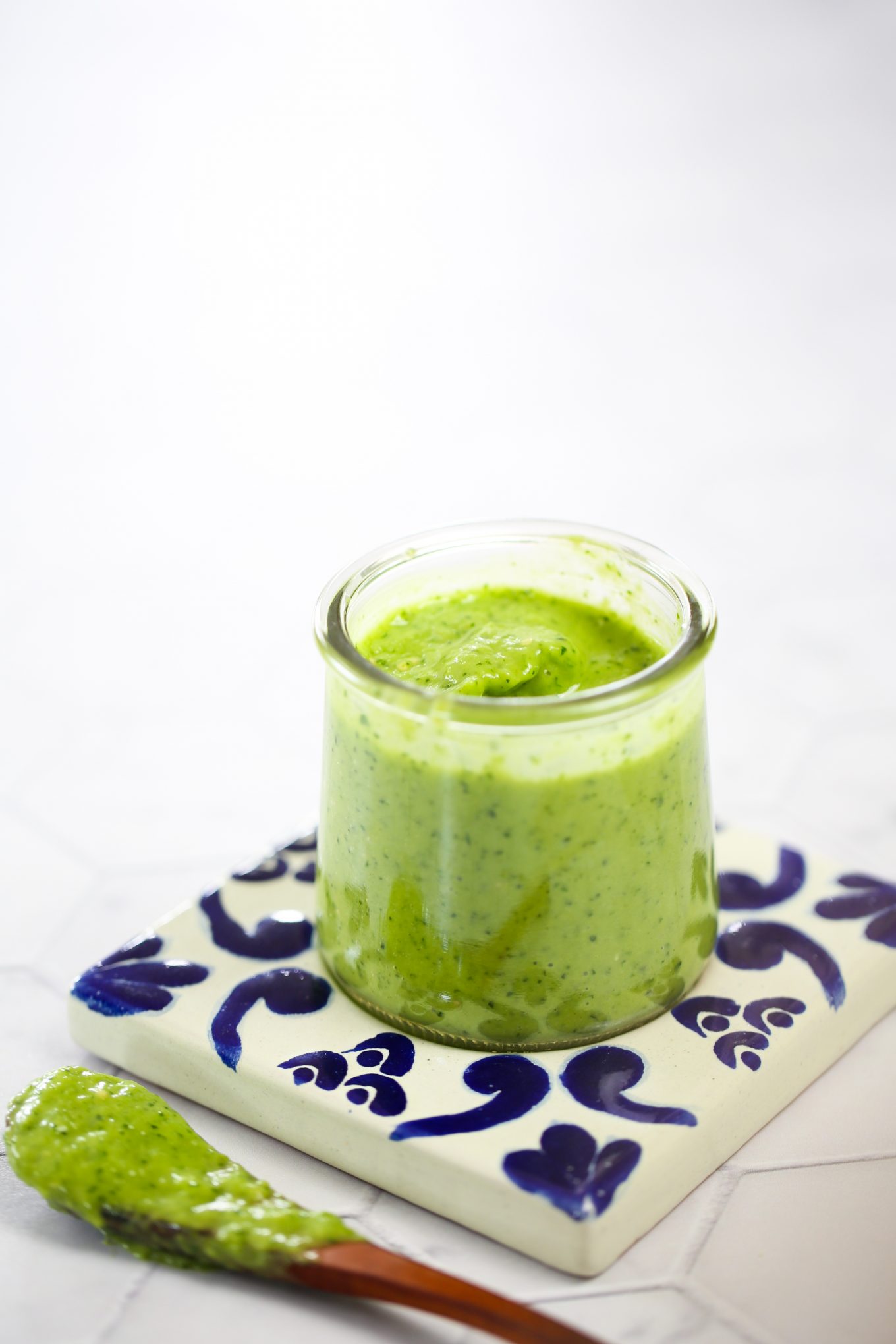 salsa verde cremosa en un bote de vidrio y sobre un plato de talavera