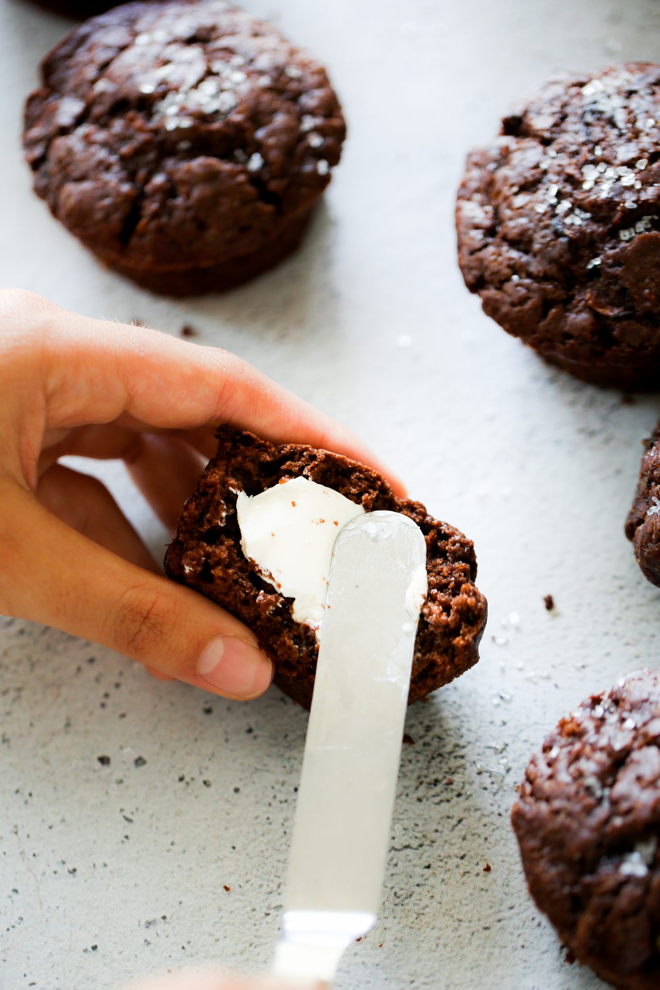 Untando mantequilla a un muffin de chocolate