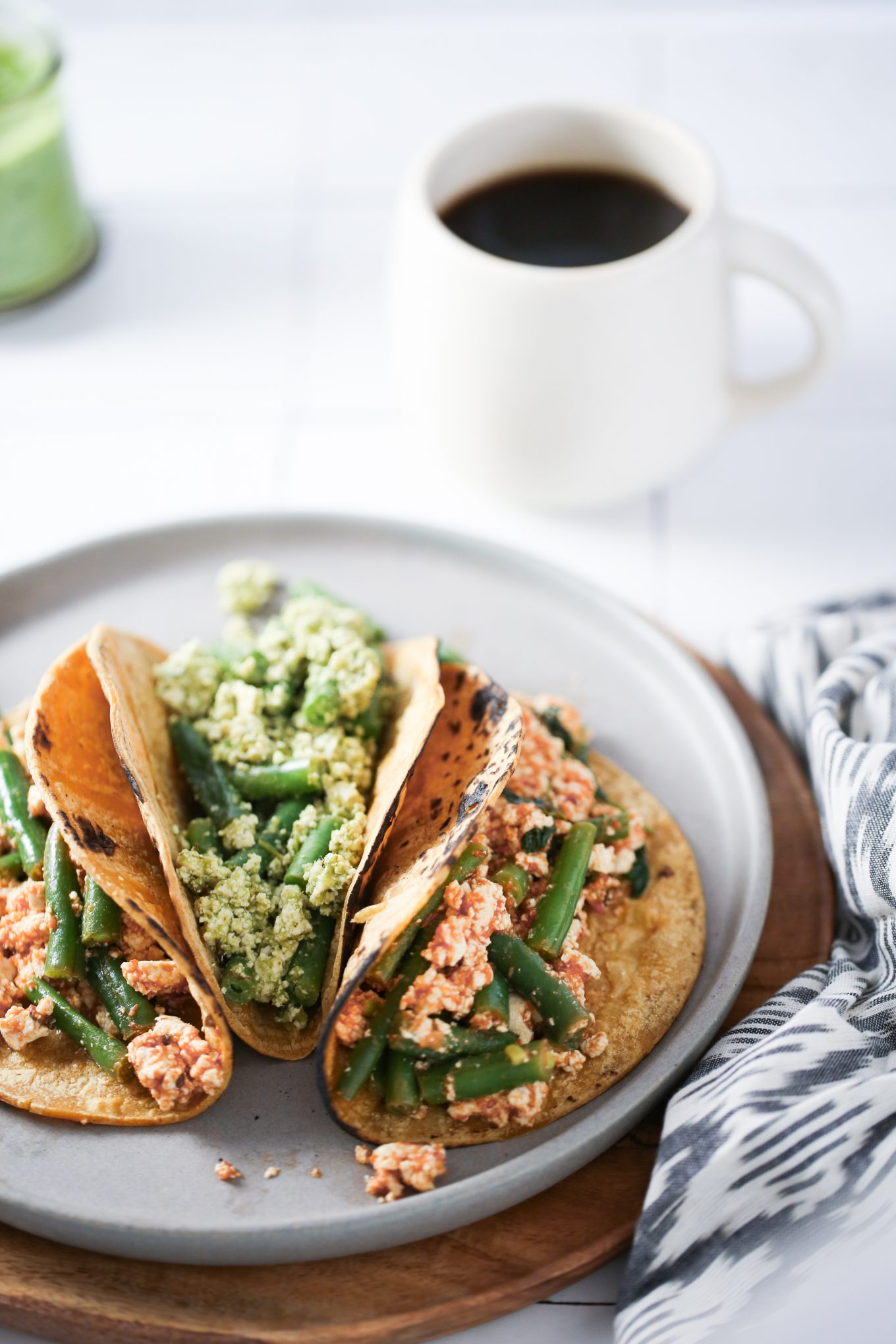 Tres tacos de tofu con ejotes, dos en salsa roja y uno en salsa verde