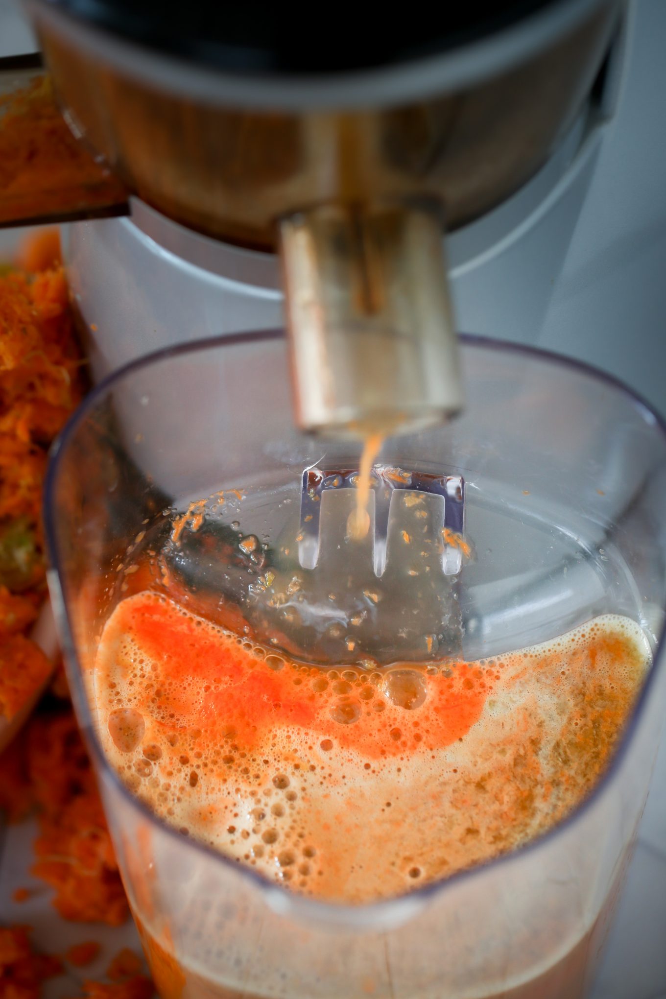 gotas de jugo de zanahoria cayendo en una jarra