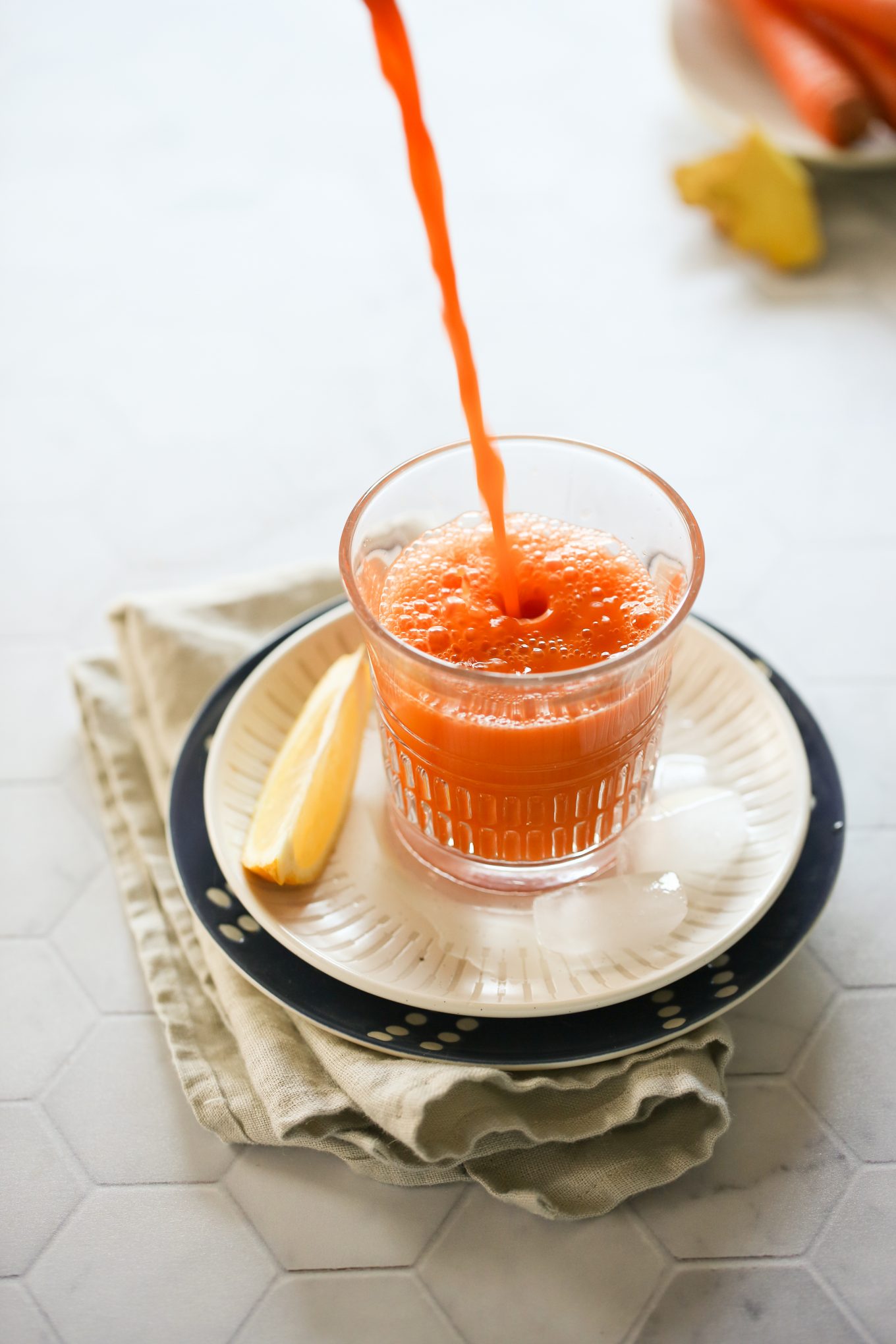 chorro de  jugo de zanahoria cayendo en un vaso.