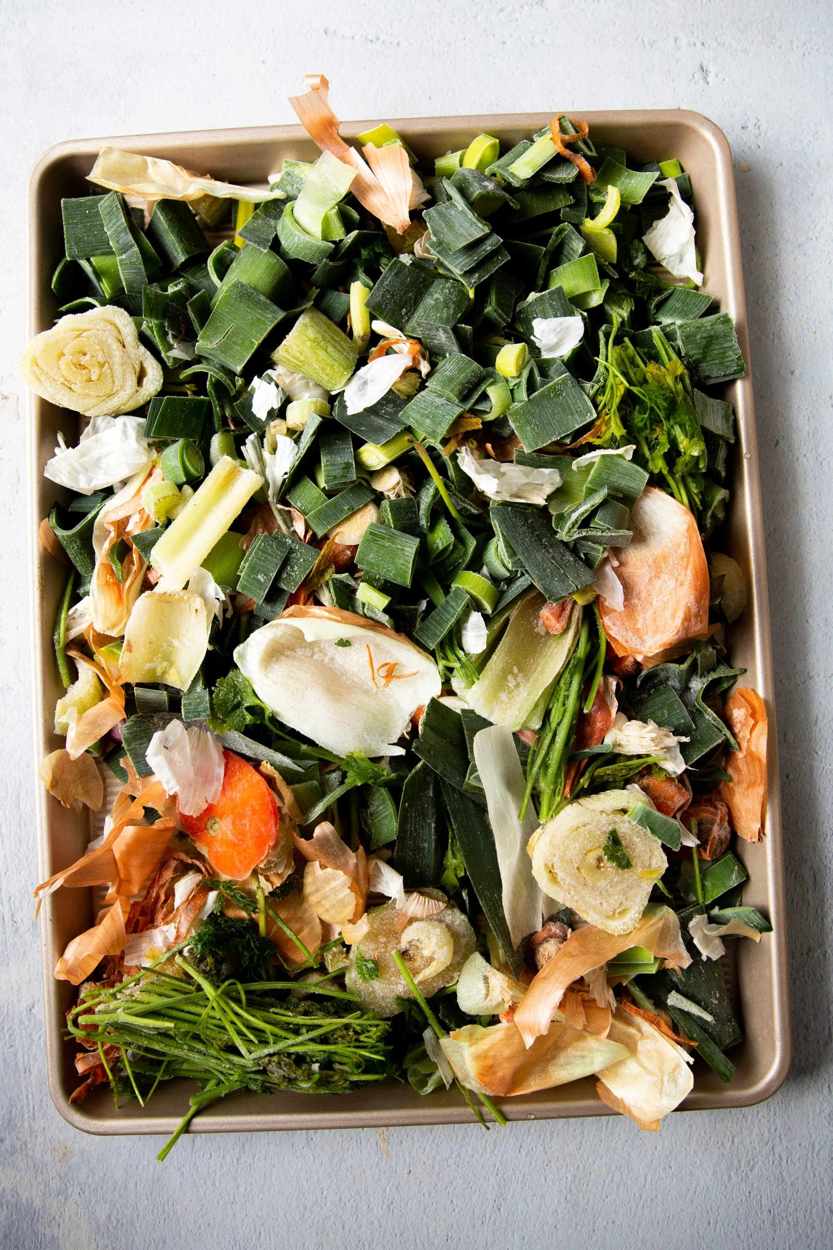 cascaras y pedazos de verduras en charola para horno