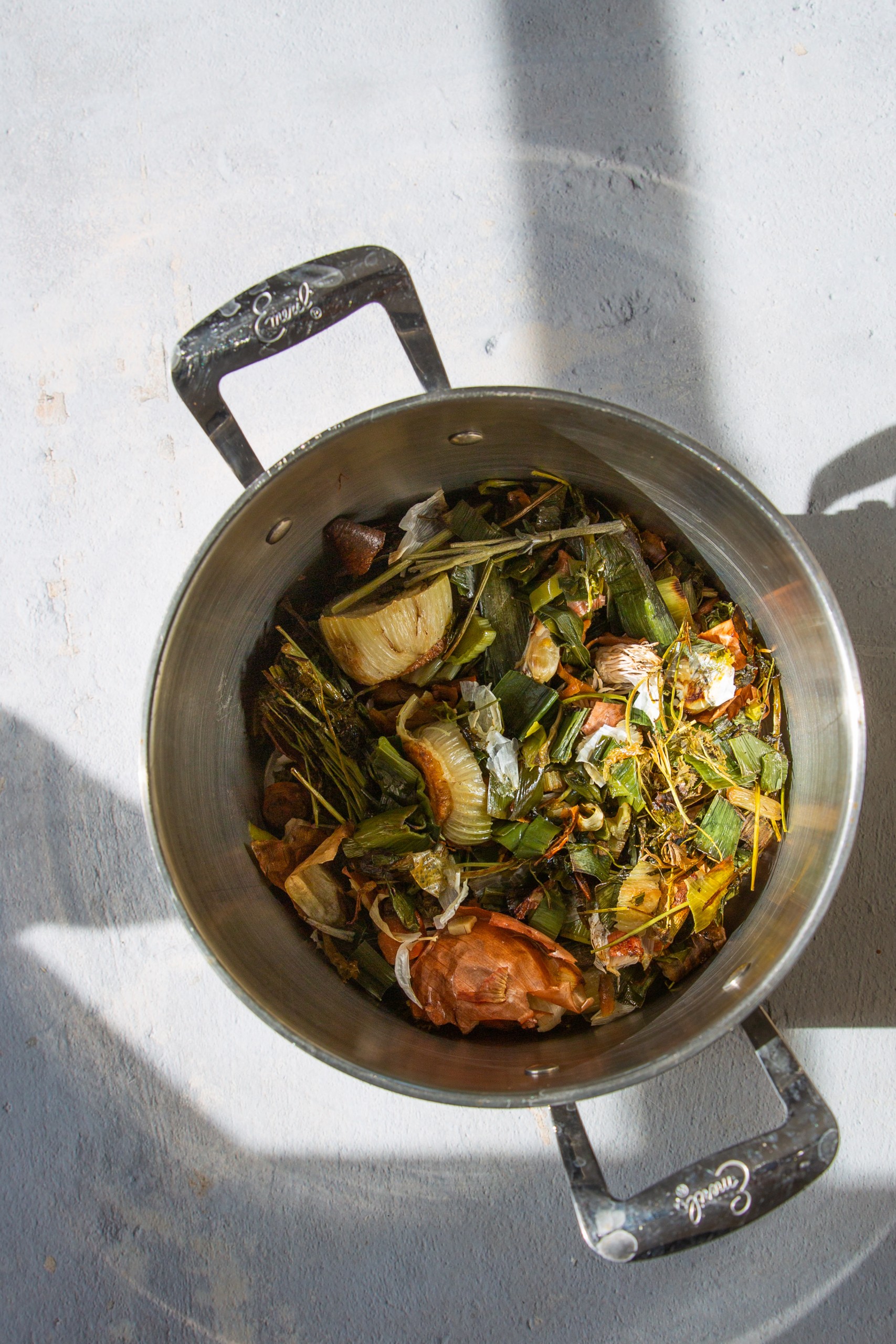 Olla de acero con verduras rostizadas hirviendo para hacer caldo