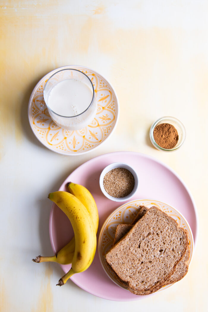 ingredientes para hacer banana nut french toast: leche, platanos, azucar y canela junto a rebanas de pan.