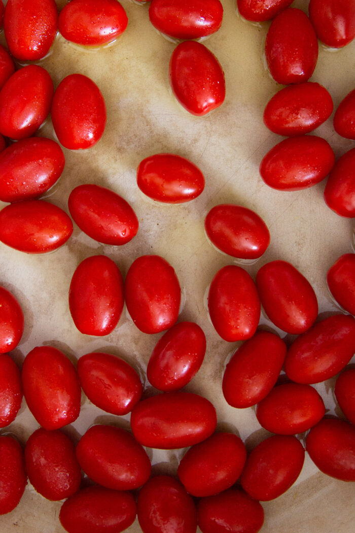 Una olla de hierro forjado con espagueti con tomates cherry y albahaca