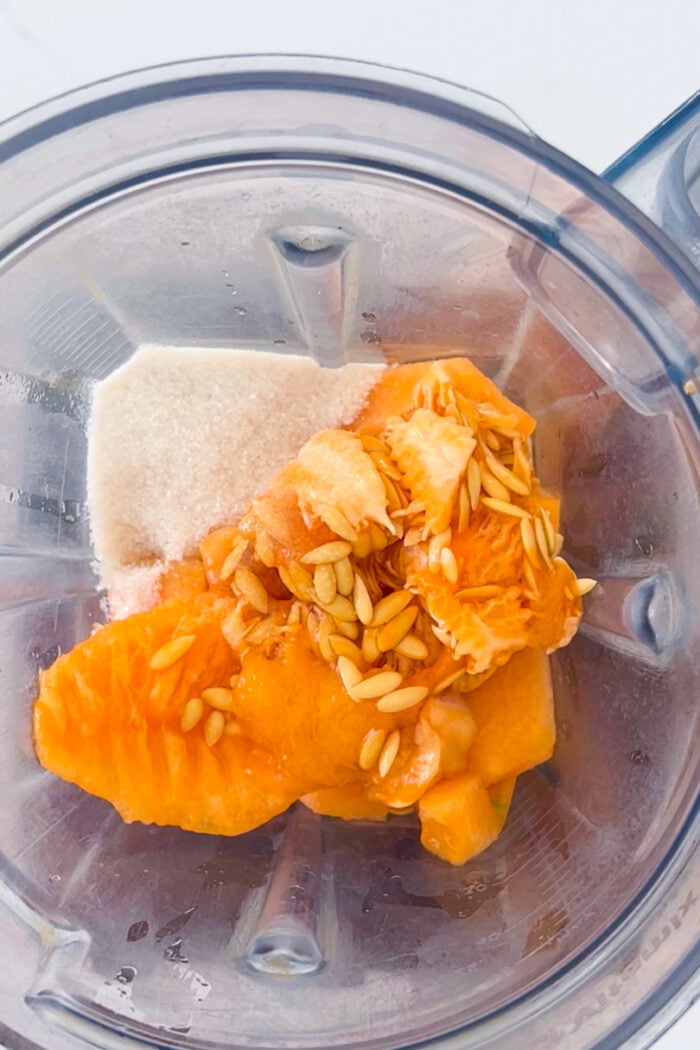 melon en cuadritos, azucar y las semillas del melón en el vaso de la licuadora