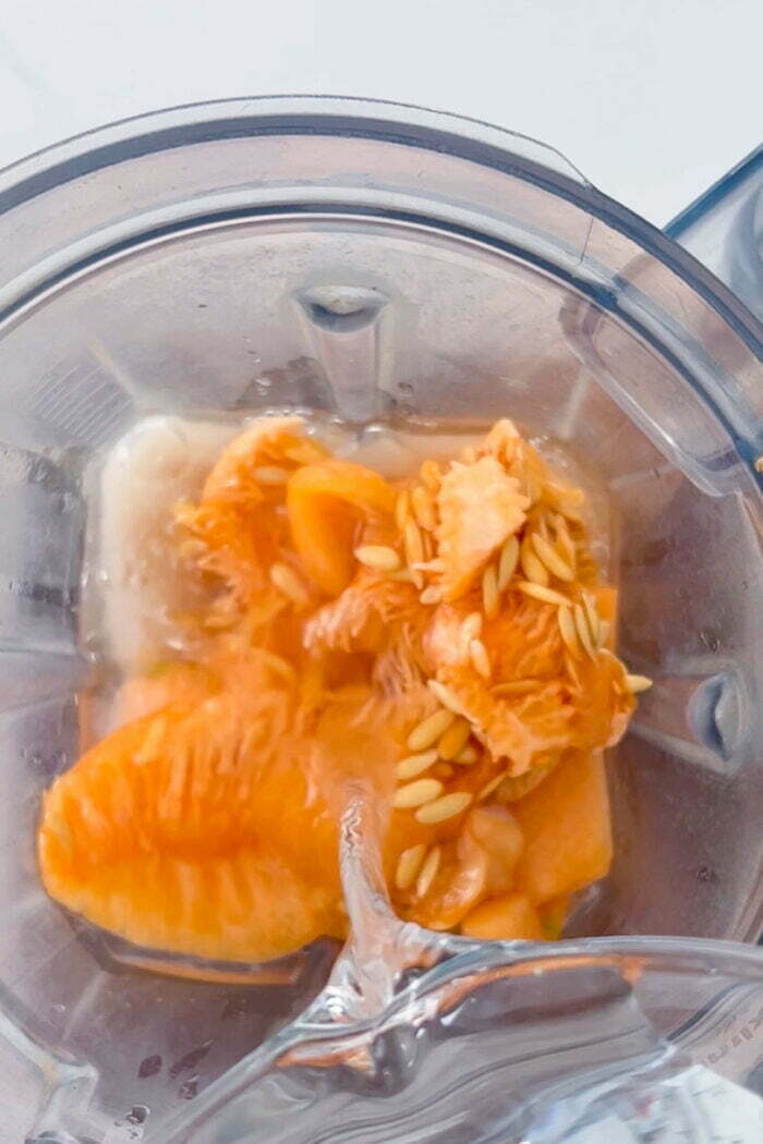 agregando agua al vaso de la licuadora para hacer agua de melon