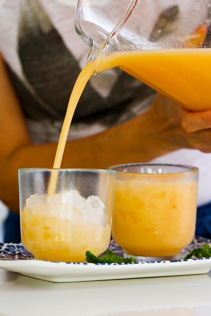 sirviendo agua de melón en vasos con hielo