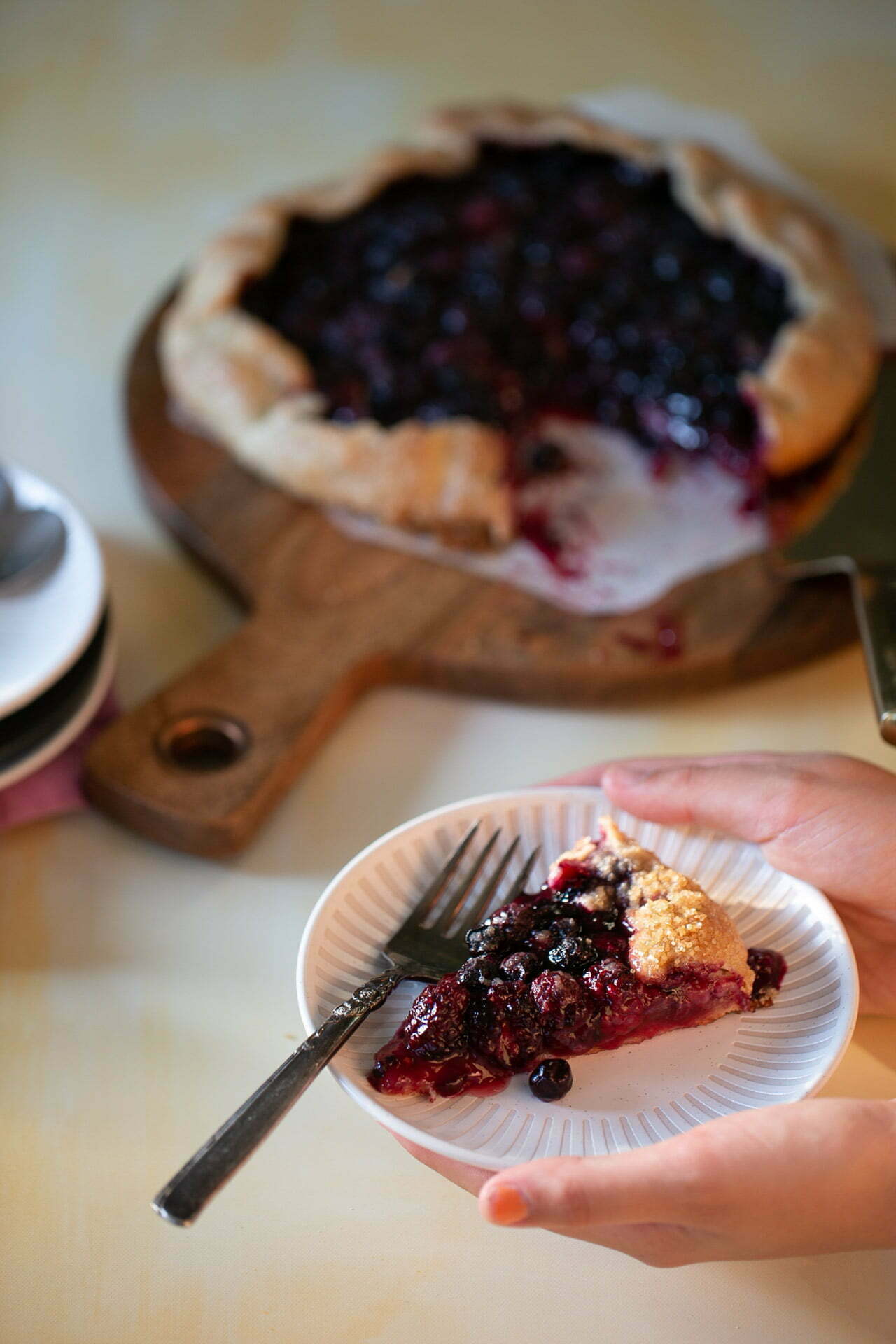 Rebanada de galette de moras vegana en un plato, con costra dorada y moras jugosas.