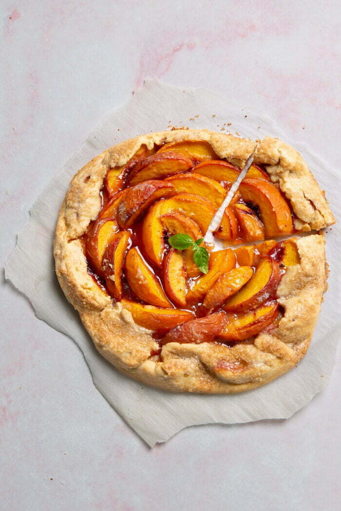 galette de durazno sobre un papel y fondo rosa.