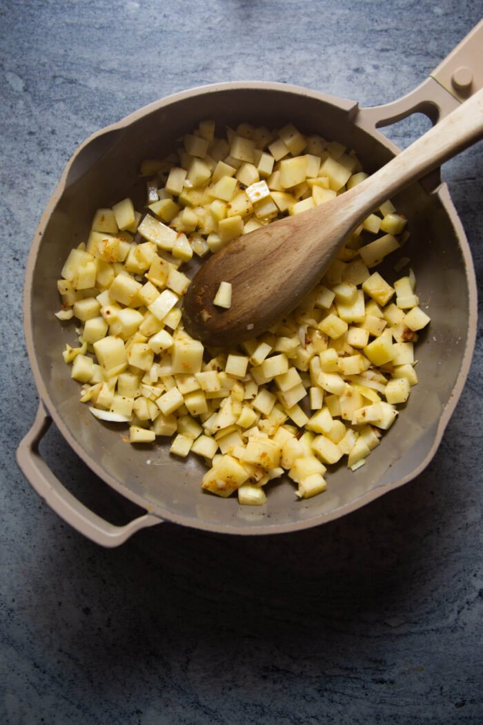 sartén con patatas a medio cocer cortadas en dados