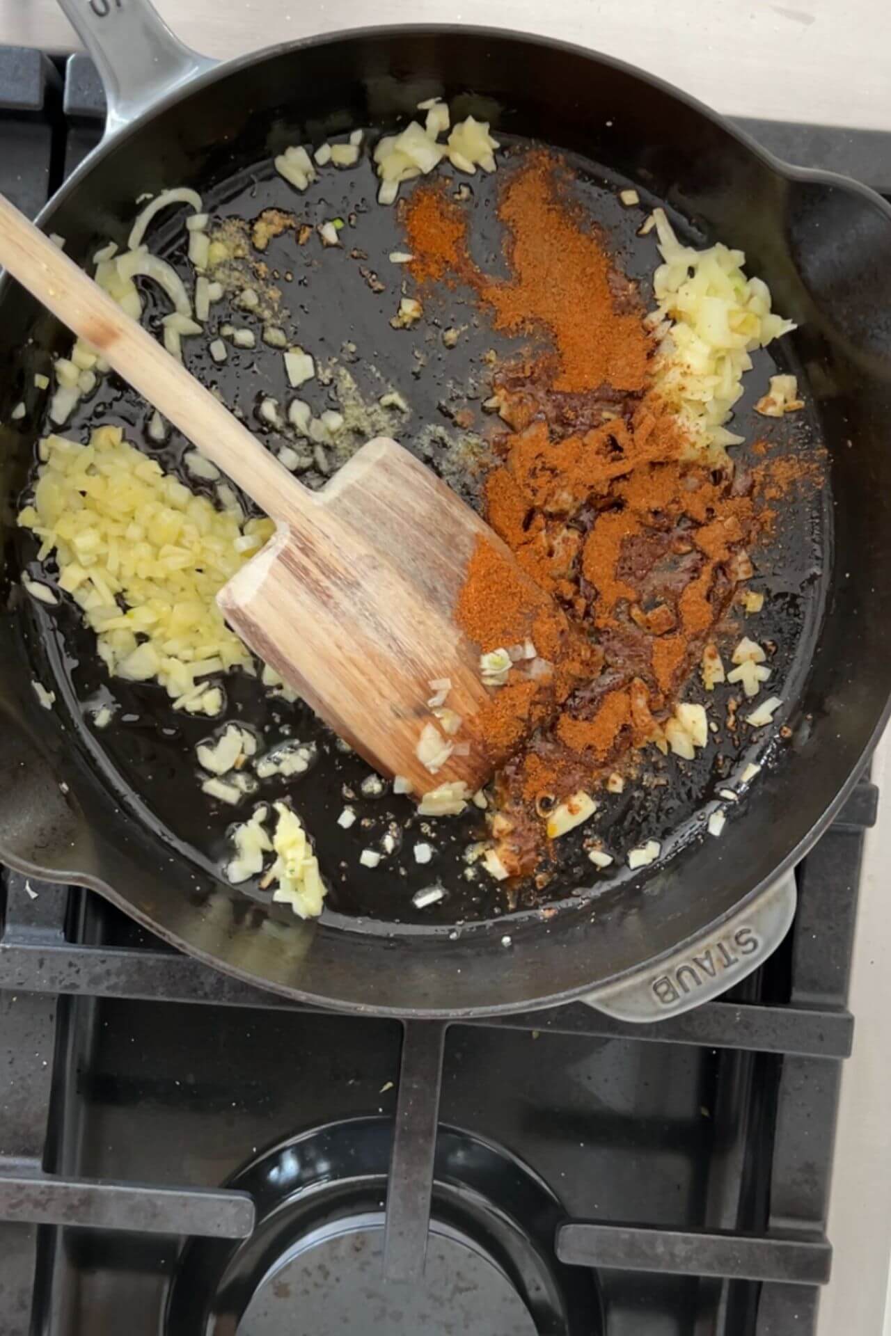 acitronando cebolla y especias en un sartén.