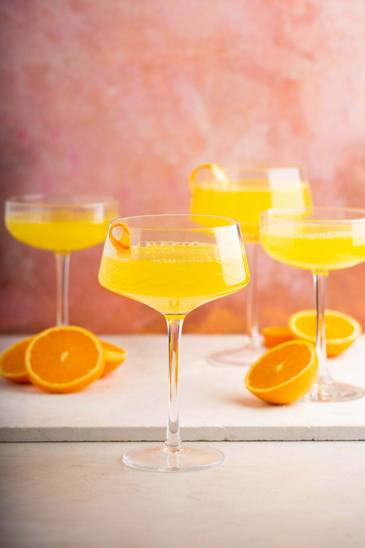 Mimosa de prosecco de cerca mostrando burbujas doradas y una rodaja de naranja.