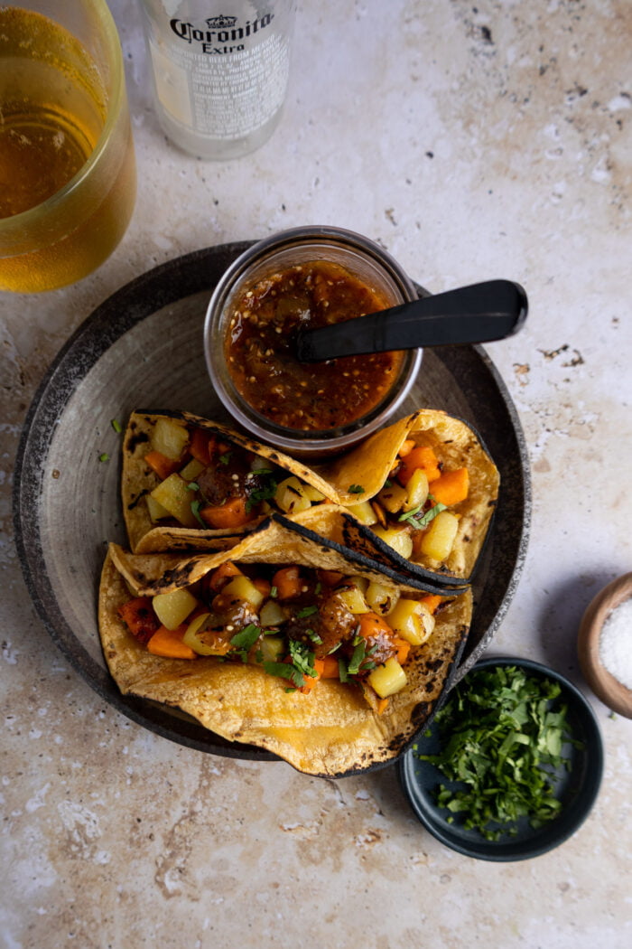 tacos de papa y camote en tortilla de maíz con salsa.