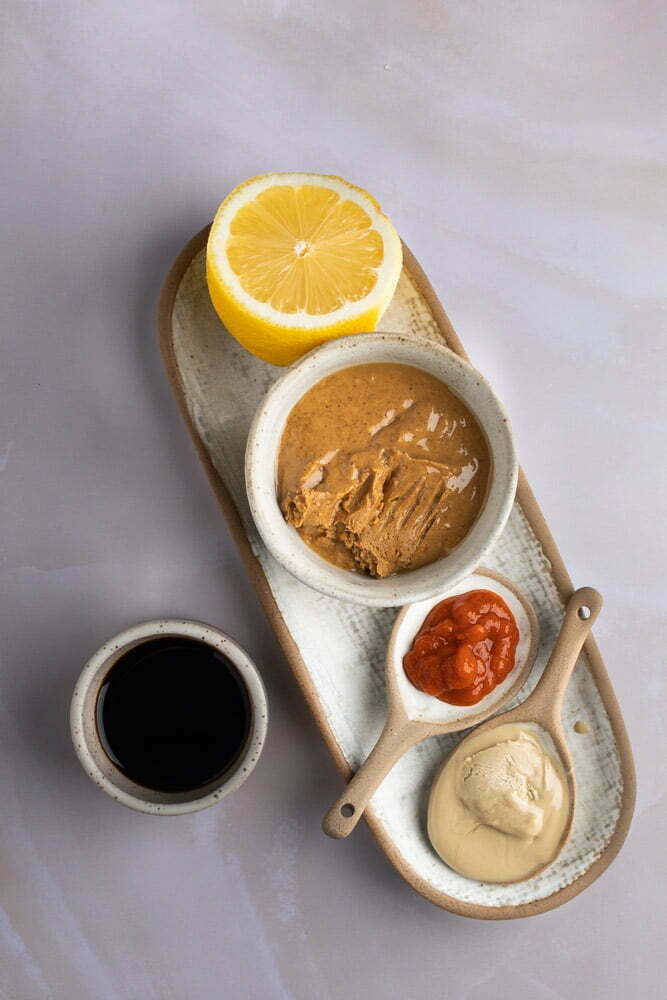 Ingredientes para salsa de cacahuate: lim&oacute;n, tahini, mantequilla de cacahuate y salsa sriracha.